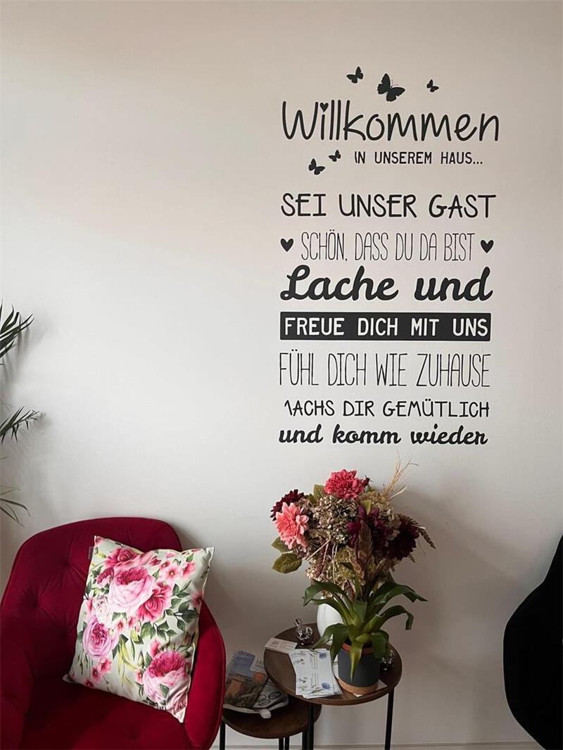 Im Flur der Wohngemeinschaft heißt ein Wand-Tattoo Besucher willkommen.