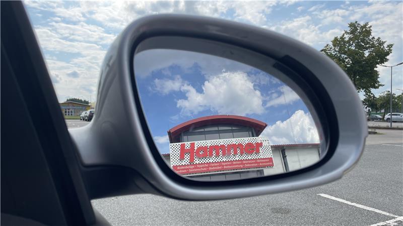 Der Hammer Fachmarkt in Stade fotografiert in einem Autospiegel.
