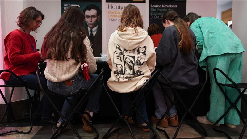 Im Foyer des Museums läuft Popmusik, während Fans Freundschaftsbändchen knüpfen.