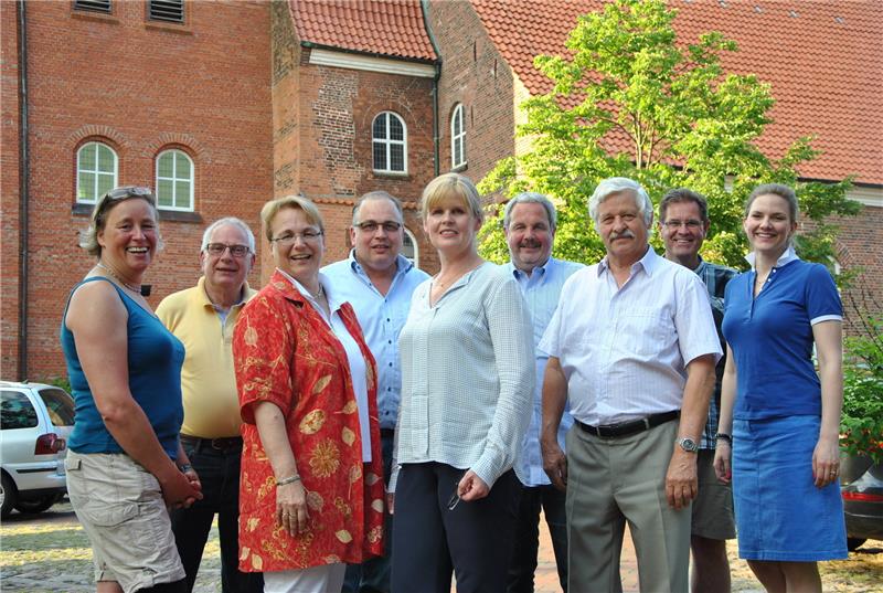 Im Hochsommer planen sie schon den Reformationstag und die Weihnachtslesung: Die Gruppe „Impuls“ – das sind Dorothee Kröger, Christoph Caesar, Hilke und Markus Harms, Karin und Johannes Kühn, Jörg Weissenborn, Raimund Franken und Pastorin Aggie-Eleanor Rilinger (von links) vor der Liebfrauenkirche in Horneburg. Foto Lohmann