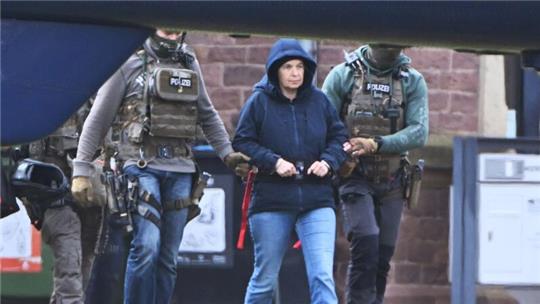 Im Innenhof eines Behördenzentrums wird die frühere RAF-Terroristin Daniela Klette zu einem Hubschrauber geführt.