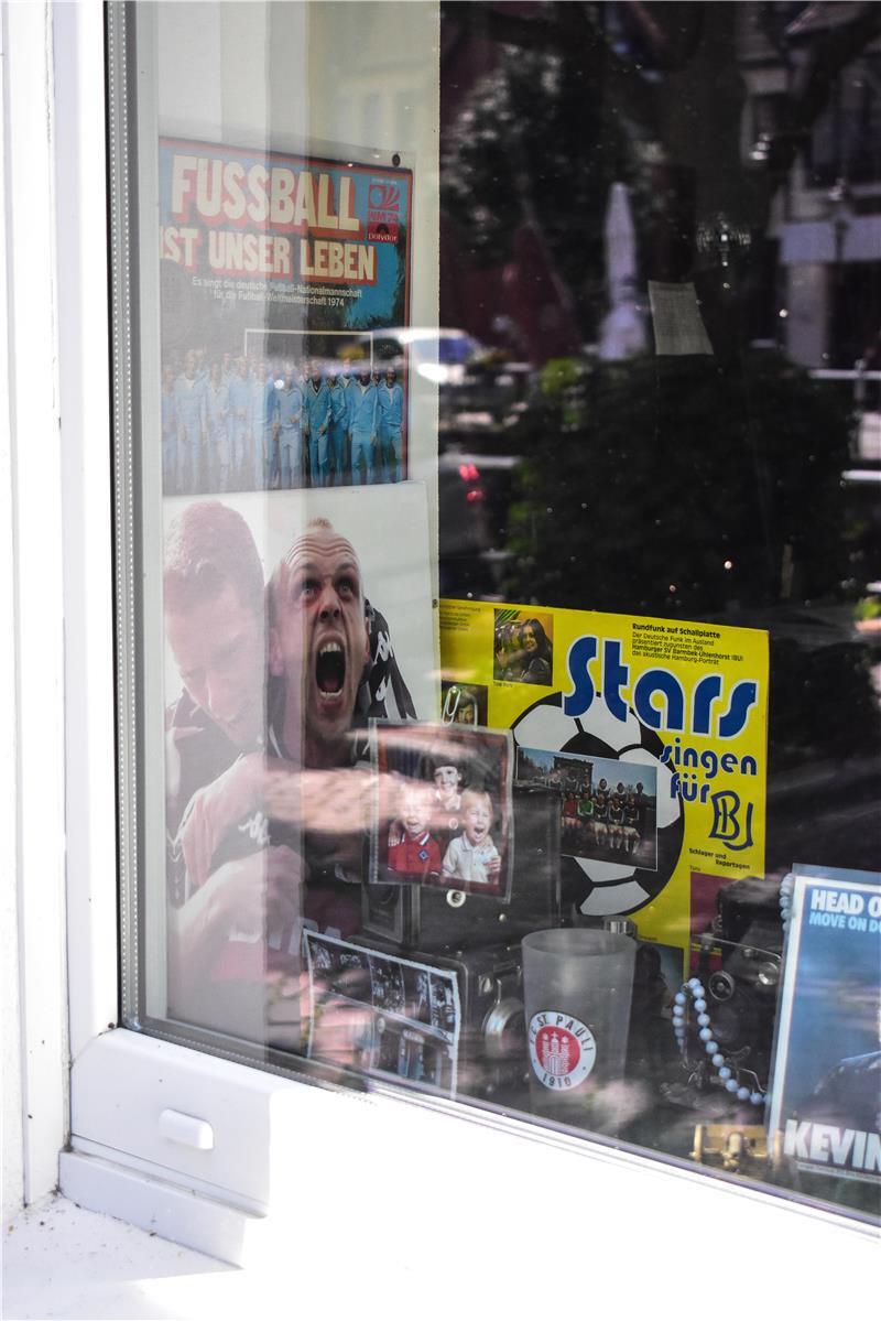 Hollywoodreif: Mit ChatGPT auf Entdeckungsreise durch Buxtehude Ein Schaufenster eines Schllplattenladens mit Fußball-Postern und -Schallplatten.