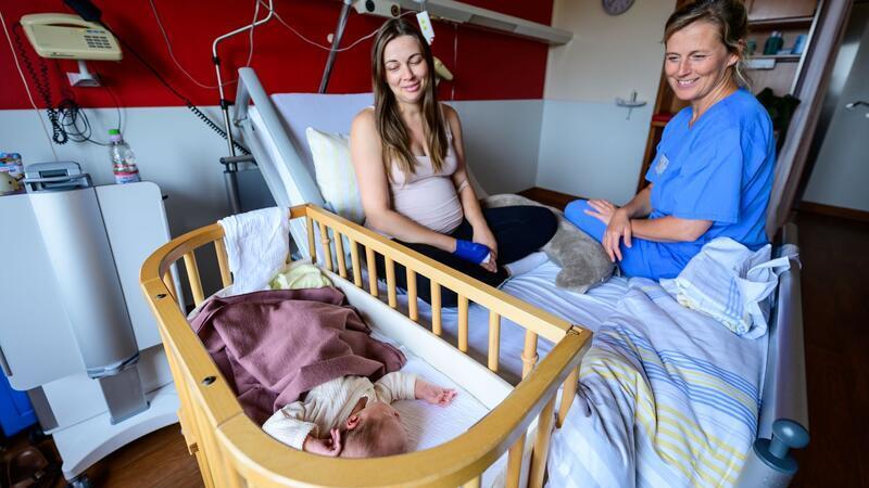 Im Klinikum Lüneburg werden Verena Ahrens und ihre wenige Tage alte Tochter von Hebamme Franziska Pfeil (r) betreut. Pfeil hat die erste Geburt im neu eröffneten hebammengeleiteten Kreißsaal im Klinikum Lüneburg betreut.