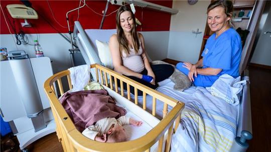 Im Klinikum Lüneburg werden Verena Ahrens und ihre wenige Tage alte Tochter von Hebamme Franziska Pfeil (r) betreut. Pfeil hat die erste Geburt im neu eröffneten hebammengeleiteten Kreißsaal im Klinikum Lüneburg betreut.
