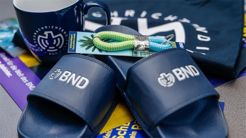 Im Merchandise-Shop gibt es T-Shirts und auch Badelatschen mit BND-Logo. 