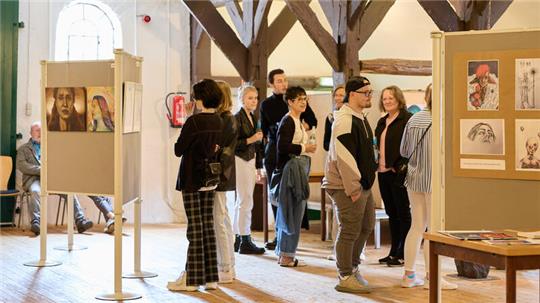 Personen schauen sich im Schloss Agathenburg Kunstwerke an.