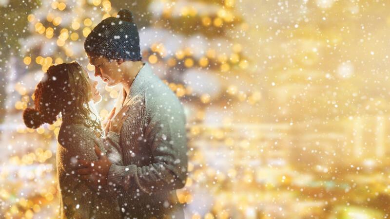 Silvester im Stadeum: Vorverkauf läuft bereits Ein junges Liebespaar steht bei Schneetreiben im weihnachtlichem Lichterglanz
