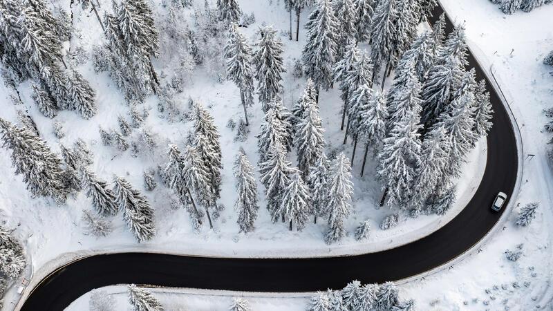 Mindestlohn, Bürgergeld, Cannabis: Drastische Änderungen in 2024 Ein Auto fährt durch Schneelandschaft.