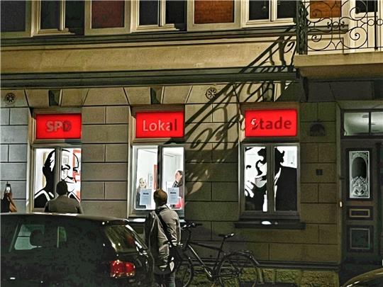 Im linken Fenster ist Clara Zetkin als Scherenschnitt zu sehen, im mittleren stehen Sarah Durke, die die Scherenschnitte angefertigt hat, und Lydia Struck, deren Urgroßtante Marie Juchacz das rechte Fenster schmückt. Foto: Richter