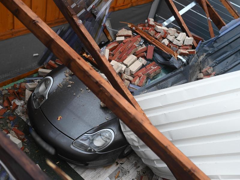 Im niedersächsichen Eversmeer liegen die Reste eines eingestürzten Daches nach dem Orkan auf einem Porsche. Foto: Lars-Josef Klemmer/dpa