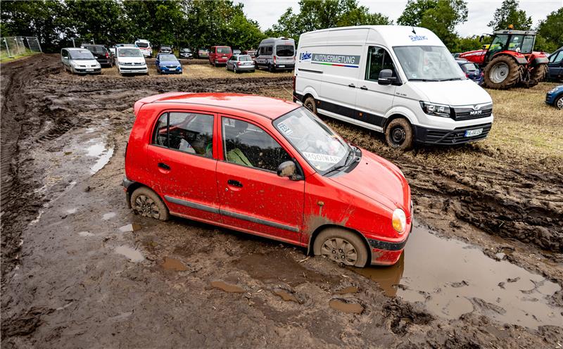 Immer noch stecken Autos tief im Schlamm auf dem Festival-Gelände in Wacken. Foto: dpa