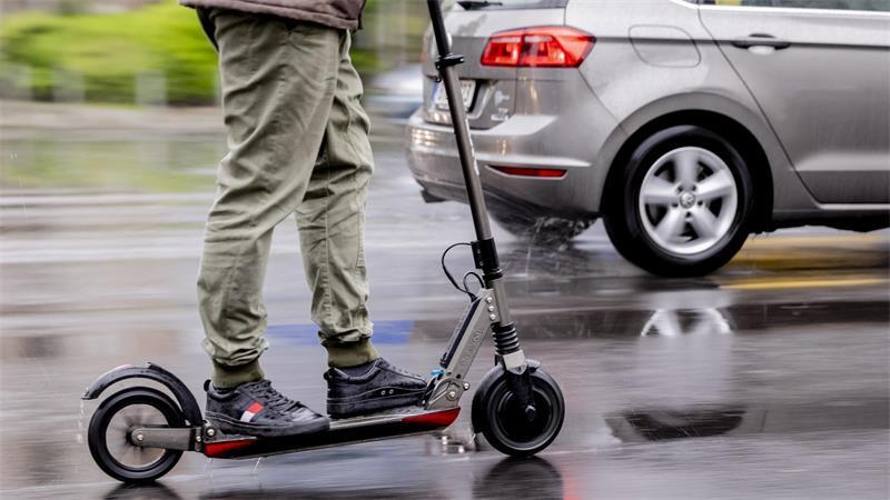 Ein Mann fährt auf einem E-Scooter.