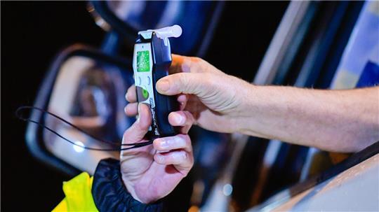 Immer wieder         Ein Autofahrer übergibt einem Polizisten ein Alkoholtestgerät.