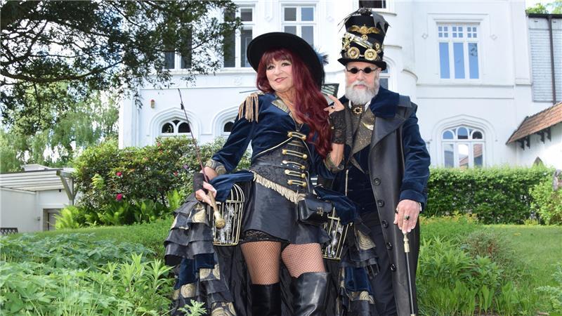 Imposant gekleidet besuchen Dagmar und Jürgen Herzer aus dem Saarland das Steampunk-Festival in Buxtehude. Die Steampunk-Darstellerin trägt eine silberne Drachenfigur unterm Rock.