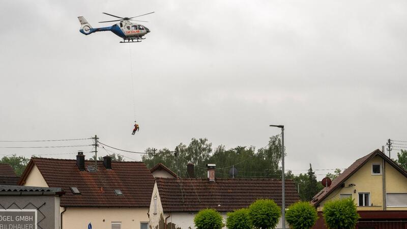 In Babenhausen wird ein Wasserretter aus einem Polizeihubschrauber abgeseilt.