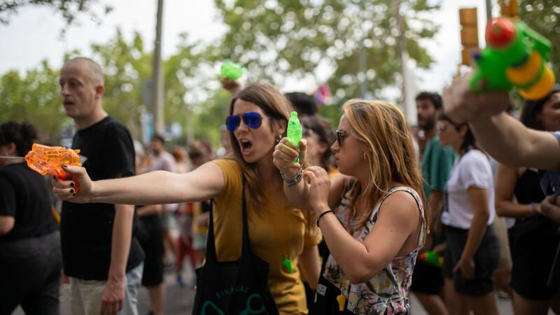 Hitze in Südeuropa plagt Urlauber und Einheimische In Barcelona bekamen Urlauber in Straßencafés eine unerbetene Abkühlung aus Wasserpistolen der Demonstranten.