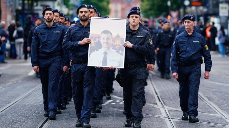 In Gedenken an ihren tödlich verletzten Kollegen Rouven Laur ziehen Polizisten durch die Mannheimer Innenstadt.