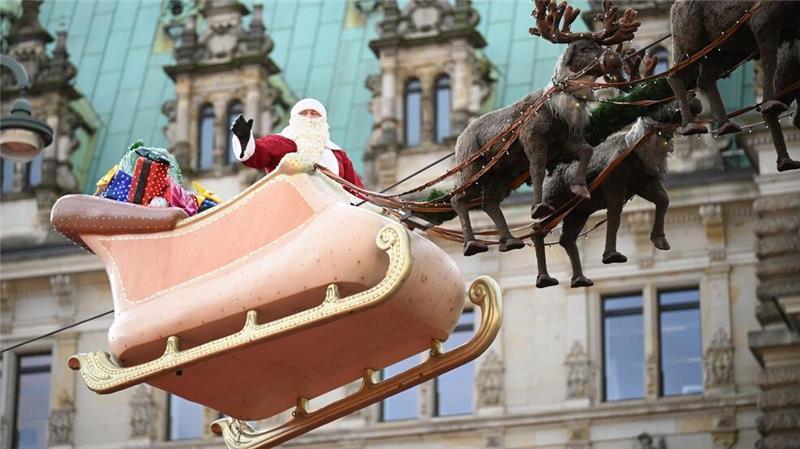 Glühwein bei bis zu 20 Grad: Viele Weihnachtsmärkte eröffnet In Hamburg flog der Weihnachtsmann in einem Rentierschlitten über den Markt vor dem Rathaus.