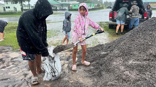 In Hawaii füllen Menschen Sandsäcke, um ihre Häuser vor den Auswirkungen von „Nolo“ zu schützen.