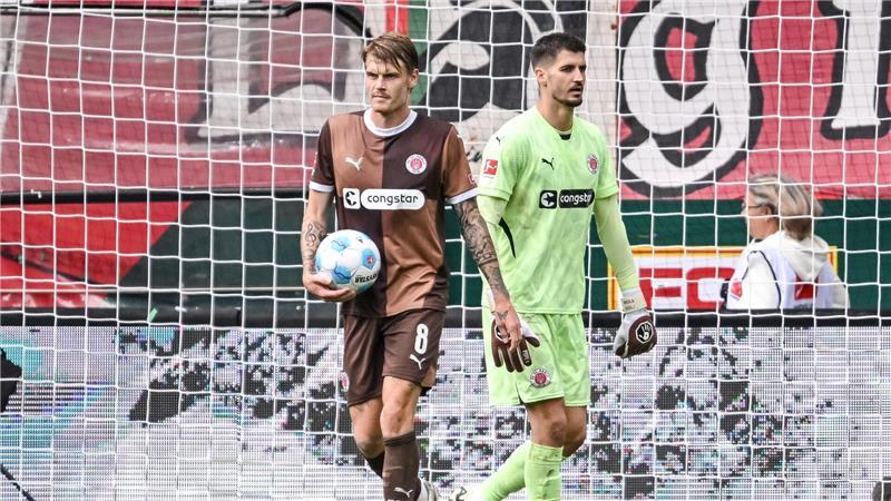 In München wartet auf St. Paulis Abwehrchef Eric Smith (l) und Torwart Nikola Vasilj viel Arbeit.