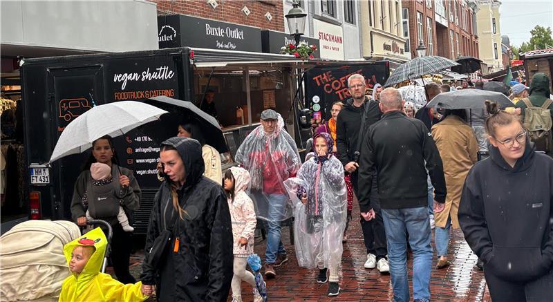 In Regenkleidung ziehen Besucher am Sonnabendnachmittag durch die Buxtehuder Altstadt.