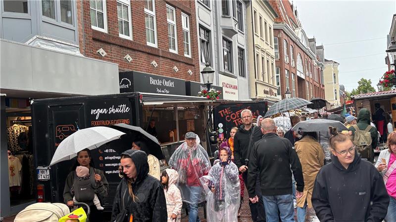 In Regenkleidung ziehen Besucher am Sonnabendnachmittag durch die Buxtehuder Altstadt.