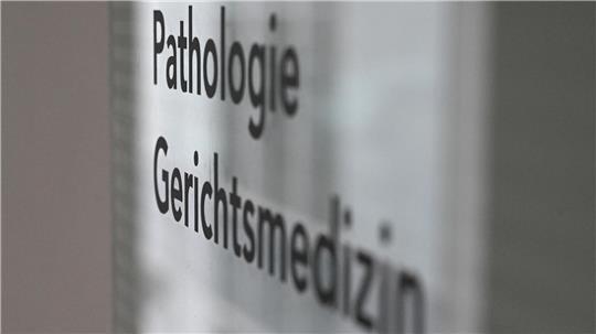 Auf einem Schild in einem Krankenhaus sind die Worte „Gerichtsmedizin“ und „Pathologie“ zu sehen.