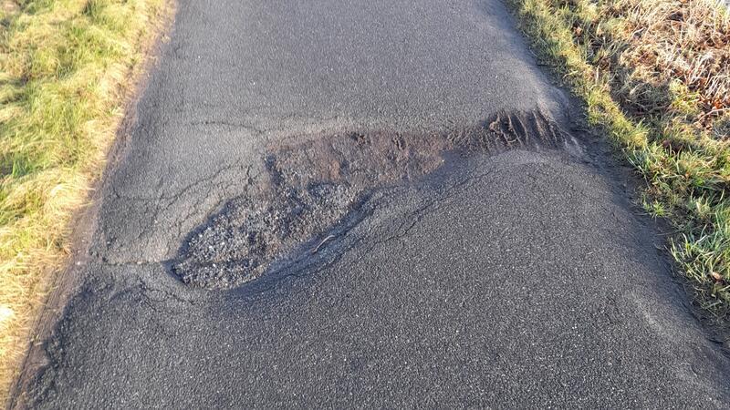 In dem Radweg klaffen große Löcher und Risse.