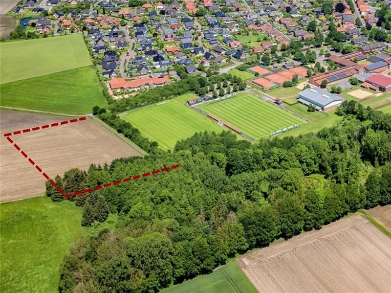 So sieht der Kompromiss für das Ahlerstedter Sportzentrum aus In dem gestrichelten Bereich soll die Sportanlage um einen Kunstrasenplatz erweitert werden. Im Wäldchen werden Rückhaltebecken das Wasser zunächst aufnehmen. Foto: Martin Elsen