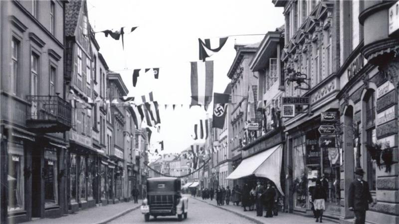 In den 30er Jahren wehen in der Langen Straße Hakenkreuz-Flaggen.