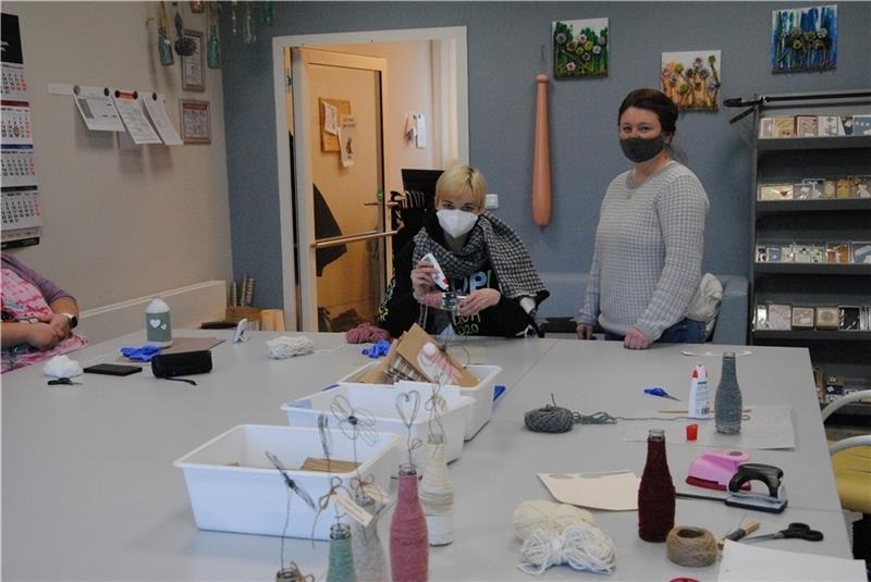In den Hansewerkstätten , die zur Lebenshilfe gehören, arbeiten 130 Menschen. Natalie (links) verziert Vasen, die im Blumenladen in der Kleinen Schmiedestraße verkauft werden. Irina Becker betreut die Werkstattgruppe.