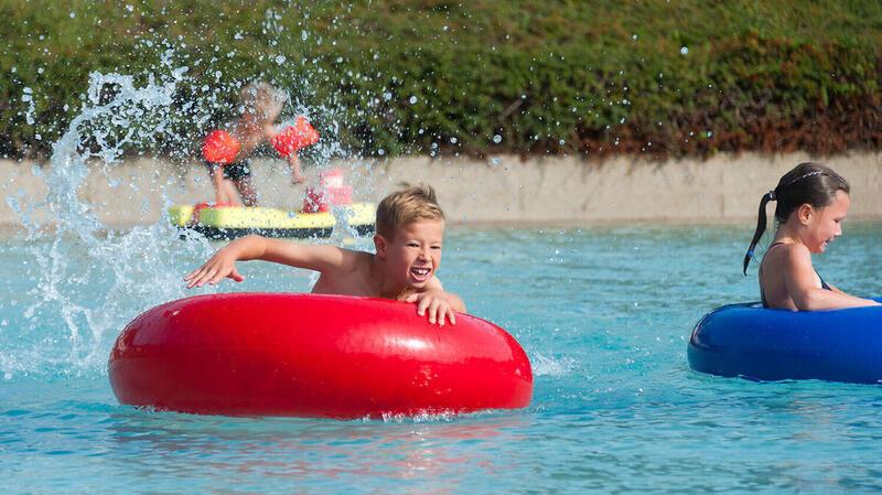 Ein Junge spielt im Schwimmbad mit einem Schwimmring.