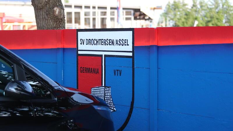 In den Vereinsfarben Blau und Rot hat D/A die Mauer am Kehdinger Stadion gestrichen.