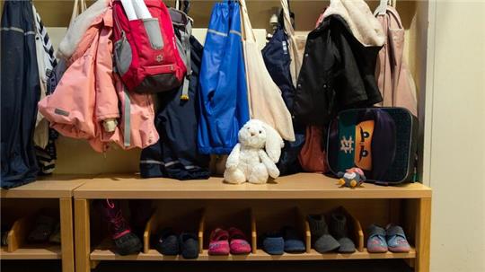 In der Garderobe in einer Kita hängen Kinderjacken.