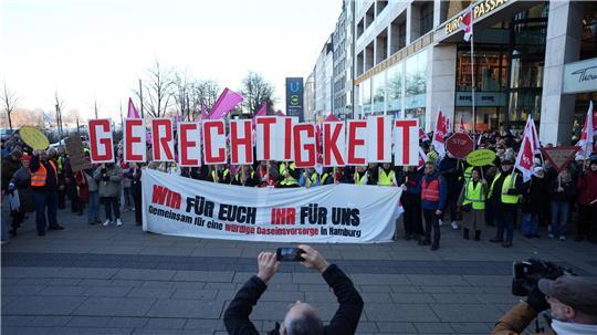 In der Hamburger Innenstadt halten Teilnehmer der Kundgebung Buchstaben in die Höhe, die das Wort „Gerechtigkeit“ bilden. 