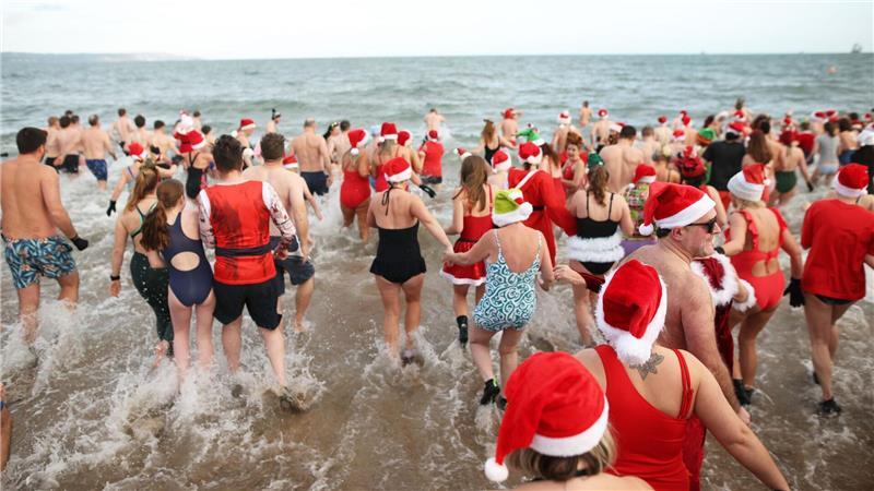 In der Helen’s Bay in Nordirland schwimmen Menschen an Heiligabend im kalten Wasser des Belfast Lough, um Geld für Dementia NI und Air Ambulance NI zu sammeln.