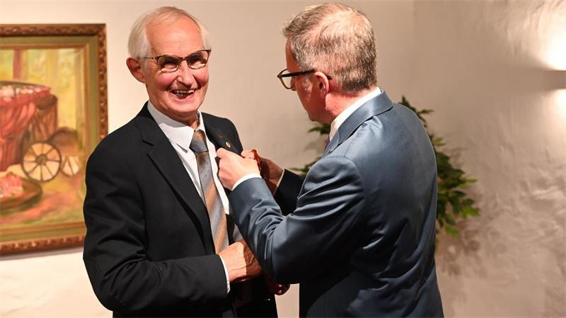 Wenn er schoss, zitterte der Gegner: Vier Anekdoten über eine Mulsum-Legende In der Mühle Anna Maria in Mulsum steckt Landrat Kai Seefried im Auftrag von Frank-Walter Steinmeier Heino Dieckmann das Bundesverdienstkreuz an.