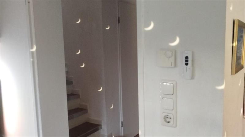 In der Spiegelung einer Disco-Kugel zeichnet sich die Sonnenfinsternis in einer Wohnung in Horneburg ab.