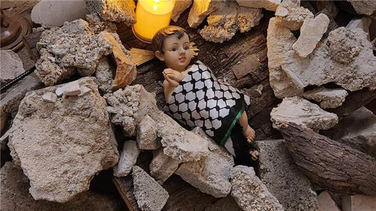 In der evangelisch-lutherischen Weihnachtskirche in Bethlehem hat Pfarrer Munther Issak diese Krippe aufgebaut: Das Jesuskind, gewickelt in ein palästinensisches Tuch, liegt inmitten von Trümmern.