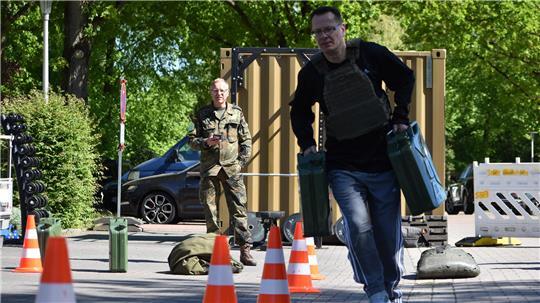 In einem Slalom-Kurs transportiert TAGEBLATT-Redakteur Thomas Sulzyc zwei jeweils 18 Kilo schwere Kanister. Die Kanister dienen als mobiler Vorrat für Kraftstoffe oder Trinkwasser.