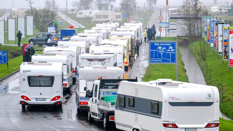 In einer langen Schlange warten die Urlauber am frühen Morgen auf die Öffnung des Campingplatzes. 