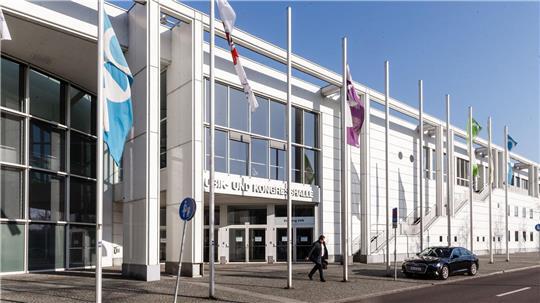 In unterschiedlichen Farben haben bisher Unbekannte großflächig Schriftzüge auf dem Steinboden vor und an einem seitlichen Fensterelement an der Musik- und Kongresshalle in der Willy-Brandt-Allee aufgesprüht (Archivbild). 