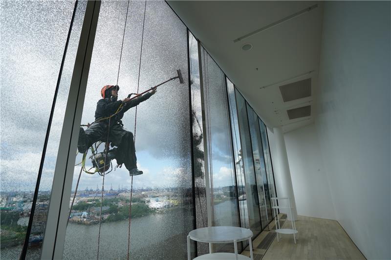 Industriekletterer reinigen die Fenster der Elbphilharmonie im Hafen. Foto: dpa