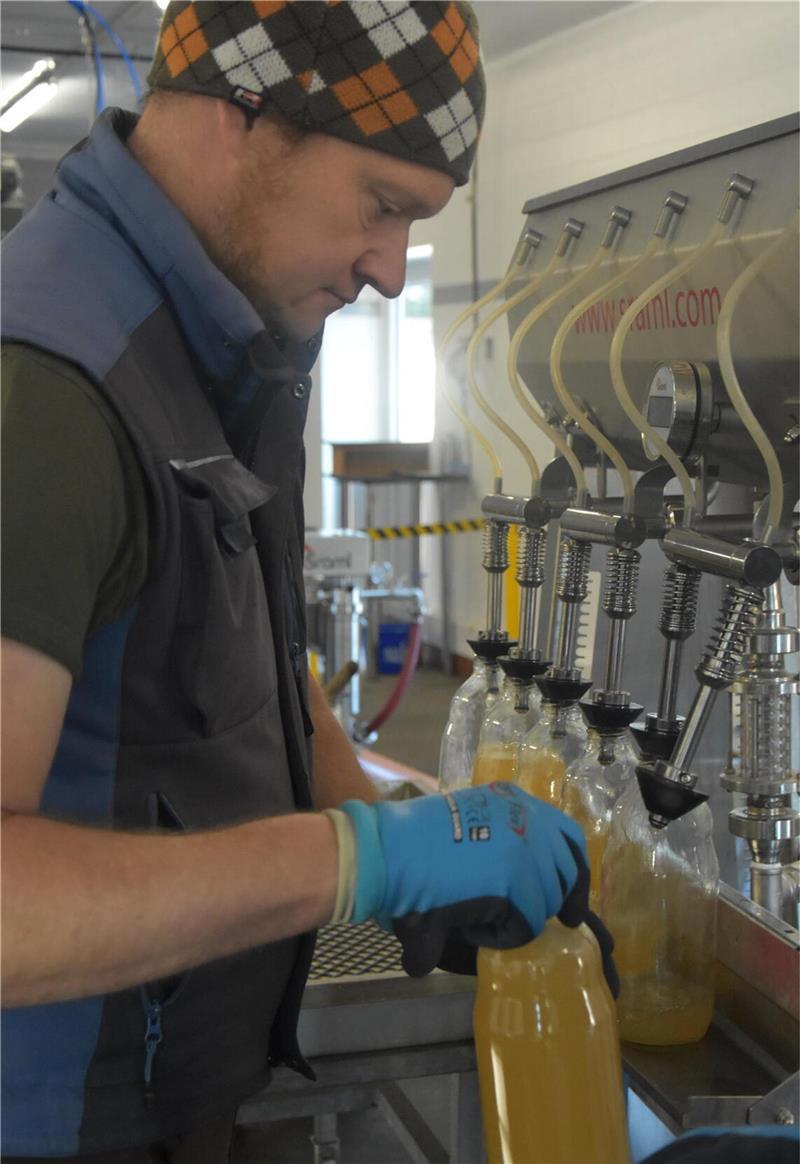 Besuch in der Mosterei: So läuft eine Apfelsaftproduktion Ingo Meinke füllt den noch heißen, frisch pasteurisierten Saft in Glasflaschen ab.