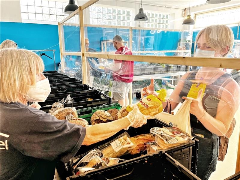 Ingrid Müller, ehrenamtliche Tafel-Mitarbeiterin in Stade, reicht der 19-jährigen Liza, die vor einem Monat aus Odessa herkam, Brot . Foto: Richter