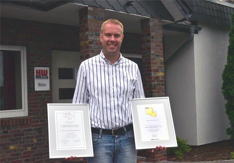 Inhaber Hauke Wiebusch präsentiert vor dem Firmensitz in Mulsum die Urkunden von Focus Business und Financial Times. Foto: Beneke