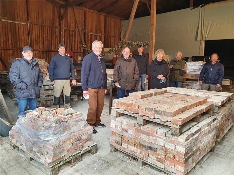 Initiatoren und Sponsoren verschaffen sich einen Einblick über das in der Scheune vorläufig eingelagerte Material für den Wiederaufbau der alten Schmiede. Foto: Beneke