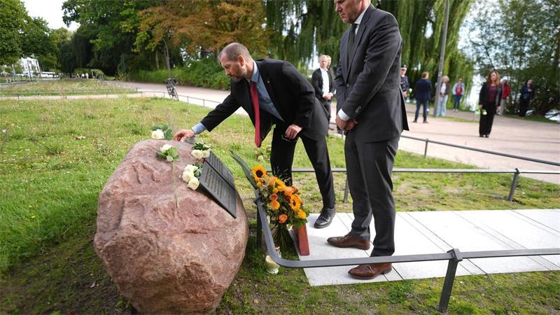 Innensenator Andy Grote und US-Generalkonsul Scott Woodard legen Blumen an einem Gedenkstein für die Opfer des 11. September 2001 nieder.