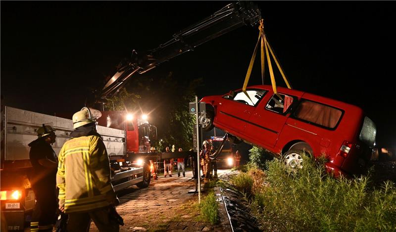Pkw versinkt am Lühe-Anleger in der Elbe - Polizei sucht Fahrerin Ins Wasser gerollt: Der Kran der Kreisfeuerwehr hob den roten VW Caddy in Grünendeich am Lühe-Anleger aus dem Wasser. Foto: Vasel