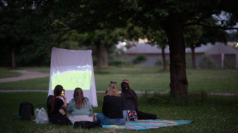 Fußball-EM 2024: Was Fans tun dürfen - und was nicht Interessantes Setting mit Leinwand im Park: Solche privaten Fußballabende sind aus rechtlicher Sicht problemlos möglich.